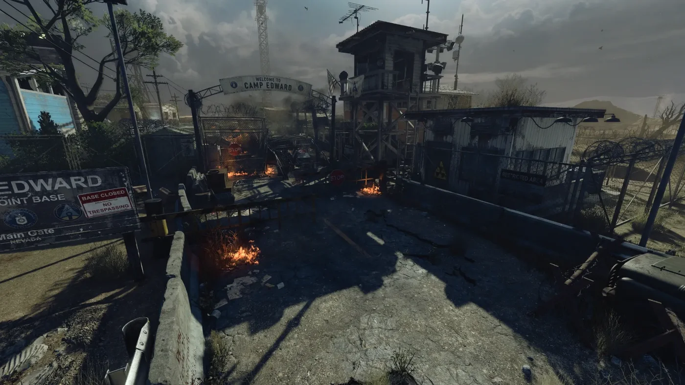 The Security Checkpoint seen from above, with the Welcome to Camp Edward gate, the watchtower and burning debris, Alpha Omega, Call of Duty Black Ops 4 Zombies