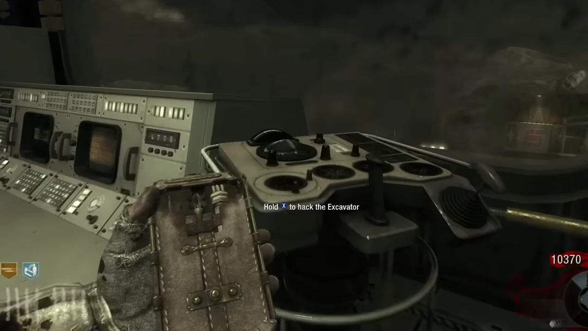 A player holding the Hacker at an excavator control panel of the Receiving Bay in Moon, Call of Duty Black Ops Zombies