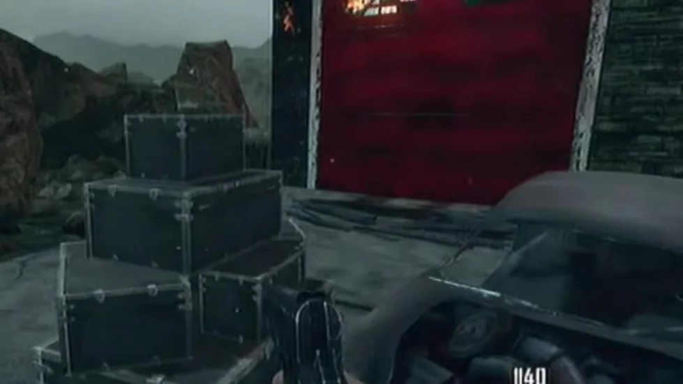 A pile of crates marking a perk landing spot, by a red garage door in Nuketown Zombies, Call of Duty Black Ops II Zombies